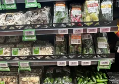 An array of packaged mushrooms and packaged hot peppers.